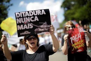 Mulheres seguram placas contra o período da ditadura