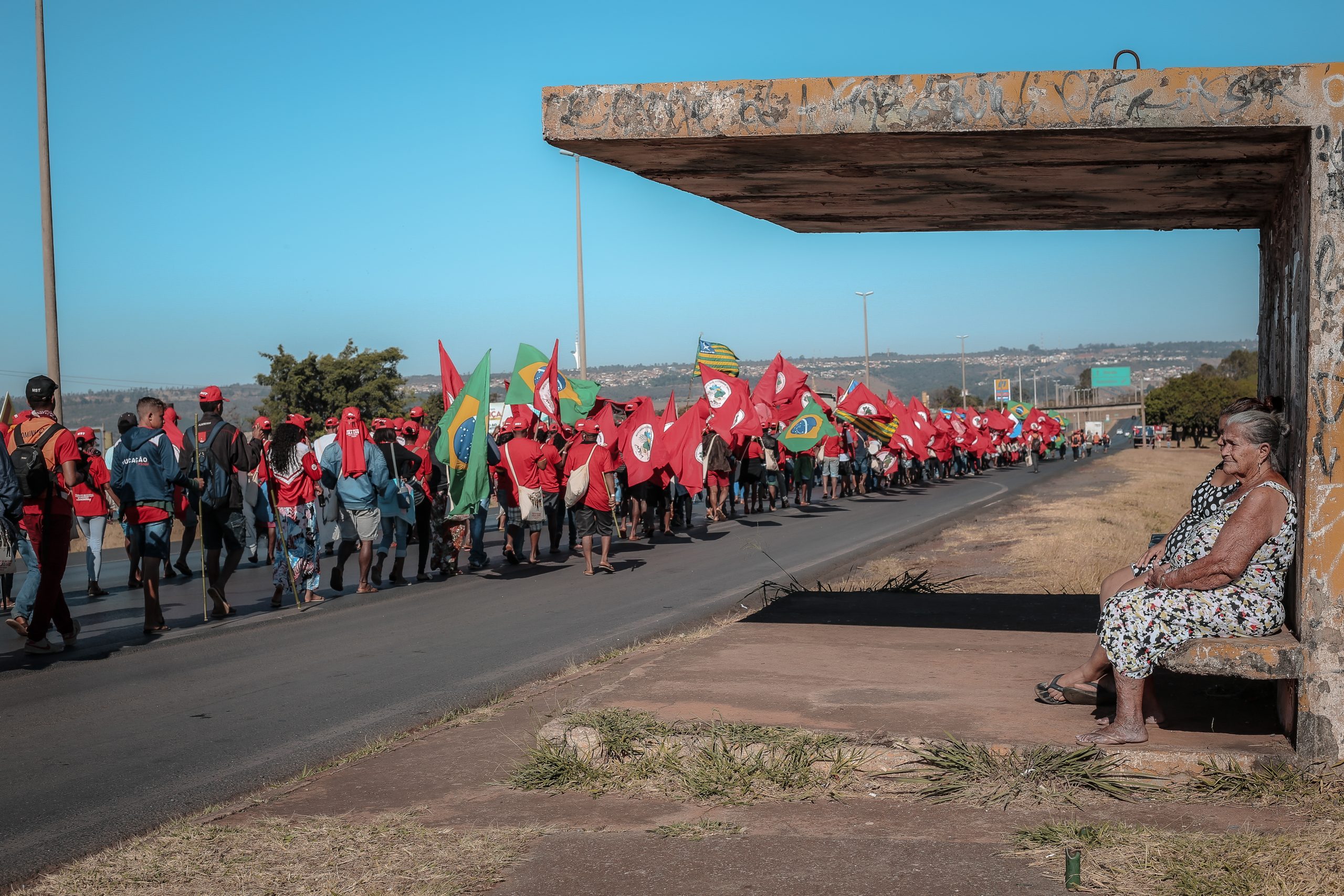 Mulheres observam passagem da Marcha Nacional do MST em Brasília - agosto de 2018