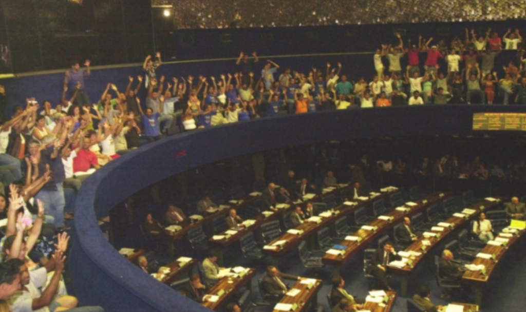 Surdos aplaudem em Libras a aprovação do PLS nº 131/96. Fonte: Roosewelt Pinheiro / Agência Senado. Jornal do Senado, Brasília.